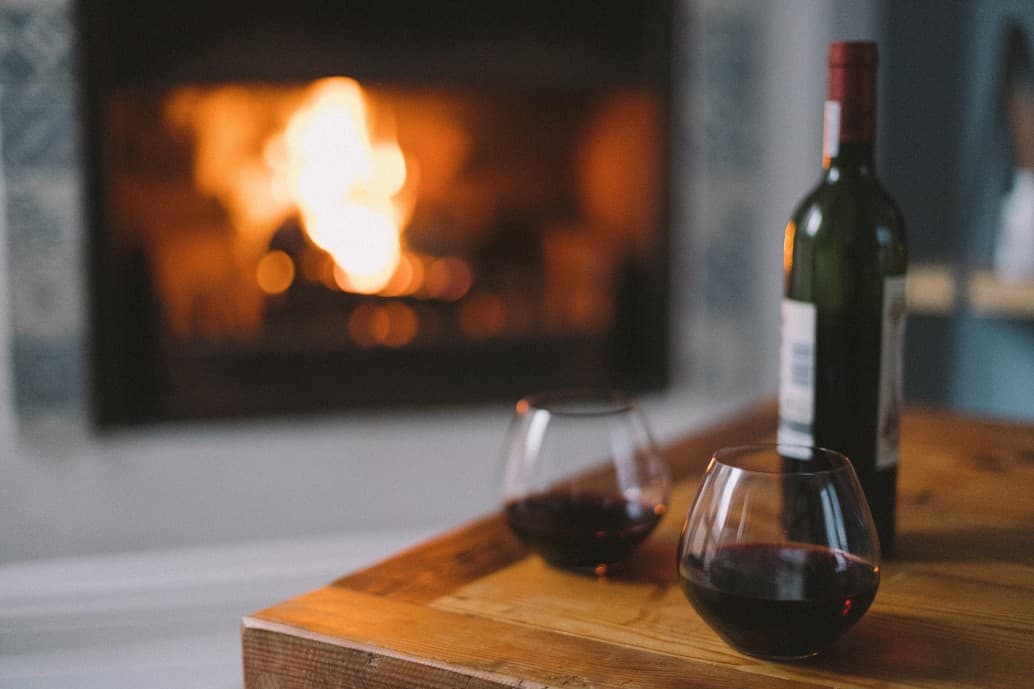 Verre de vin devant une cheminée